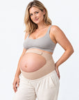 Gestante usando cinta gestacional bege Arkemis com apoio sob a barriga