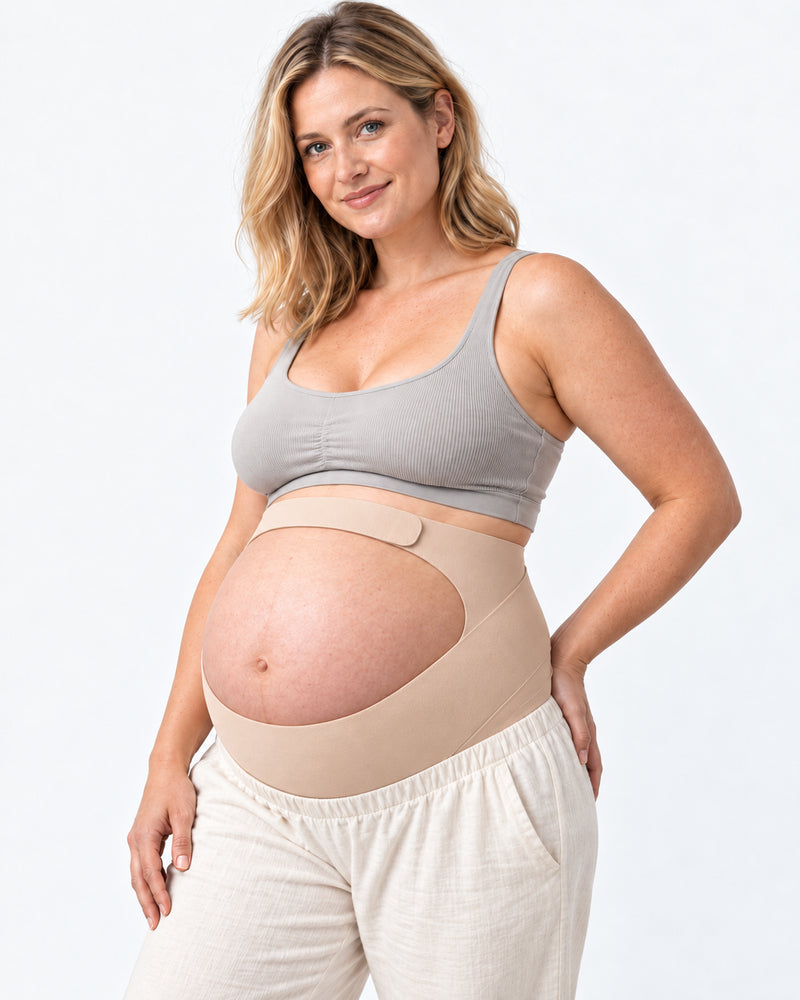 Gestante usando cinta gestacional bege Arkemis com apoio sob a barriga