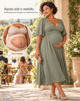 Gestante de vestido verde em uma recepção de casamento, com detalhe circular da cinta gestacional bege Arkemis sob a roupa