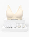 Kit Primeiras Mamadas Arkemis: sutiã de amamentação Jelly Strip bege, almofadas absorventes e protetores de leite sobre pódio.